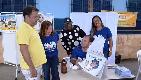 Prefeito acompanhando explicações sobre hanseníase durante ações de saúde