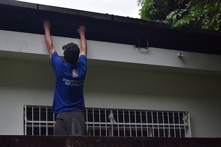 Agente de Endemia flagrado durante a inspeção de uma calha residencial