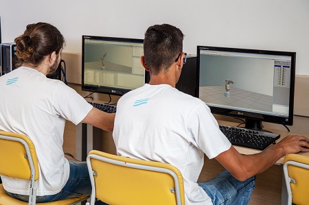 Alunos do SENAI mecatrônica operando braço robótico no computador.