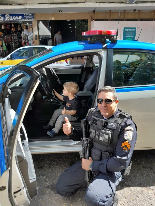 Tive que postar essa foto. Que amor ver o pequeno MIGUEL dentro da viatura da polícia. Ele é apaixonado. E o policial PAULO dos ANJOS, com carinho e empatia, cumpriu a vontade do linducho Miguel. A vovó ANGELA e o pequeno são grudadinhos. Grande abraço para você, Paulo, e muitos beijinhos para a vovó e o netinho. Viver cada bom momento da vida é a regra.